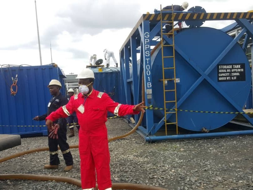 Crew performing tank entry with safety harness and rigging